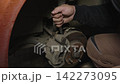 Professional auto mechanic unscrewing a bolt on a car brake caliper with a wrench during a maintenance service in a repair shop, ensuring vehicle safety and performing necessary repairs 142273095