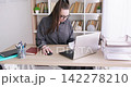 Business manager. Office lifestyle. Female specialist working at desk at professional modern workplace using laptop notebook barefoot. 142278210
