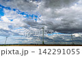 Timelapse of Wind Turbines Rotating Under Fast Moving Storm Clouds in Agricultural Field 142291055