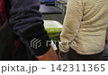 People are waiting for their suitcases as they are being transported by conveyor 142311365