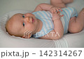 Active baby secured in soft baby nest looking around. Close-up. 142314267