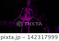 Close-up Halloween yard scene with a giant skeleton, glowing eyes, and a pink flamingo float. Purple LED lights illuminate the spooky outdoor decoration against dark trees. 142317999
