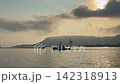 A tugboat departs the beautiful sea at dawn. 142318913