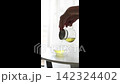 ガラス急須からグラスカップへ緑茶を最後まで注ぎきる手元（縦型動画素材） 142324402