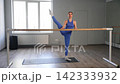 Portrait of elegant active sporty fit woman exercising side bend barre stretch workout, improving flexibility and body extension while practicing sports training in fitness studio. 142333932