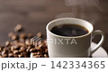 Hot coffee and coffee beans on the table 142334365