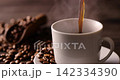 Pour hot coffee into a coffee cup. 142334390