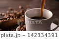 Pour hot coffee into a coffee cup. 142334391
