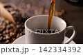 Pour hot coffee into a coffee cup. 142334392
