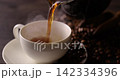 Pour hot coffee into a coffee cup. 142334396
