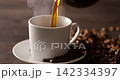 Pour hot coffee into a coffee cup. 142334397