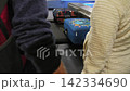 Two men standing next to the baggage conveyor waiting for luggage, 4k 142334690