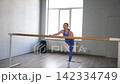Graceful sporty fit attractive woman practicing barre fitness workout, doing push-ups and leg stretches, building upper body strength and enhancing lower limb flexibility while exercising in health 142334749