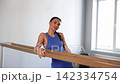 Portrait of attractive fitness woman in activewear looking with warm radiant smile at gymnastic barre, expressing natural beauty, confidence, happiness and wellness while posing indoors. 142334754