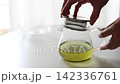 緑茶が入った透明なガラス急須に茶こし一体型の蓋を閉める手元・注ぐ準備（動画素材） 142336761