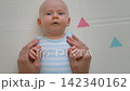 Baby holding father's thumbs with tiny hands. Close-up. Slow motion. 142340162