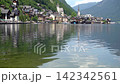 Calm in Hallstatt Village on Lake Alpine Mountains and water waves in Austria. Old houses. Green hill background 142342561