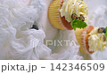 Delicious cupcakes with white frosting and blueberries on a textured white surface 142346509