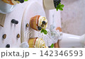Fresh vanilla cupcakes with white frosting blueberries and mint on a textured surface 142346593