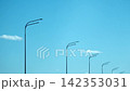 Rows of modern streetlights against a clear blue sky on a sunny day, urban infrastructure and city road lighting viewed from below. 142353031