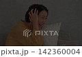 一位中年婦女被客廳的雷聲嚇壞了。 142360004