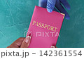 Airport check-in. Travel safety. Immigration officer hand in protective glove taking female passenger passport in pink cover on blue set of 4 loop. 142361554