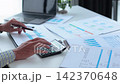 Businessman working at office desk using calculator analyzing financial charts data in office. 142370648