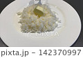 Adding Butter to Steamed Rice for Flavor 142370997
