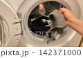 Loading clothes into washer for fresh clean 142371000