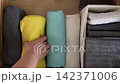 Sorting vibrant towels neatly in a drawer 142371006
