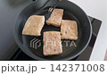 Frying crispy tofu blocks in a pan 142371008