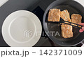 Flipping pancakes onto plate for breakfast 142371009