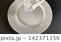 Sprinkling seasoning on white plate for use 142371156