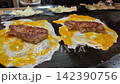 Teppanyaki egg and pork steak on hot plate cooking Japanese traditional food 4k 142390756