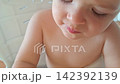 Young toddler enjoying a juicy pear while eating 142392139