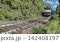 An old-style passenger express train runs on a model railway layout. 142408197
