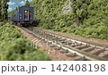 An old-style passenger express train runs on a model railway layout. 142408198