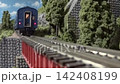 An old-style passenger express train runs on a model railway layout. 142408199