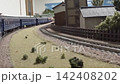 An old-style passenger express train runs on a model railway layout. 142408202