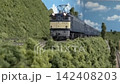 An old-style passenger express train runs on a model railway layout. 142408203