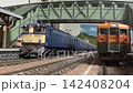 An old-style passenger express train runs on a model railway layout. 142408204