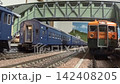 An old-style passenger express train runs on a model railway layout. 142408205