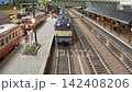 An old-style passenger express train runs on a model railway layout. 142408206