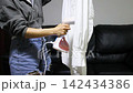 ironing a white shirt with a clothes steamer 142434386