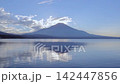 Lake Yamanaka and Mount Fuji before sunset / The calm lake surface reflects clouds and mountain silhouettes. 142447856