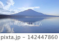Mount Fuji and clouds reflected in Lake Yamanaka at dusk / A serene reflection on the lake's surface 142447860