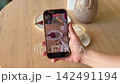 Food Blogger Filming Raspberry Dessert and Coffee with Smartphone for Social Media Content in Modern Cafe 142491194