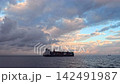 A large container ship sailing across a sea of dynamic clouds and a sunrise; live-action video footage available for commercial use. A large container ship sailing across a sea of dynamic clouds and a sunrise; live-action video footage available for commercial use. 142491987