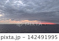 A crimson sunrise peeking through the clouds and a calm ocean; live-action video footage available for commercial use. A crimson sunrise peeking through the clouds and a calm ocean; live-action video footage available for commercial use. 142491995