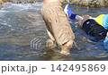 A video of a parent and child playing in the water. 142495869